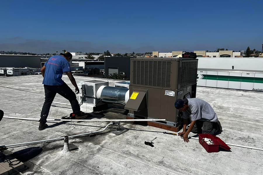 Two HVAC technicians installing ac